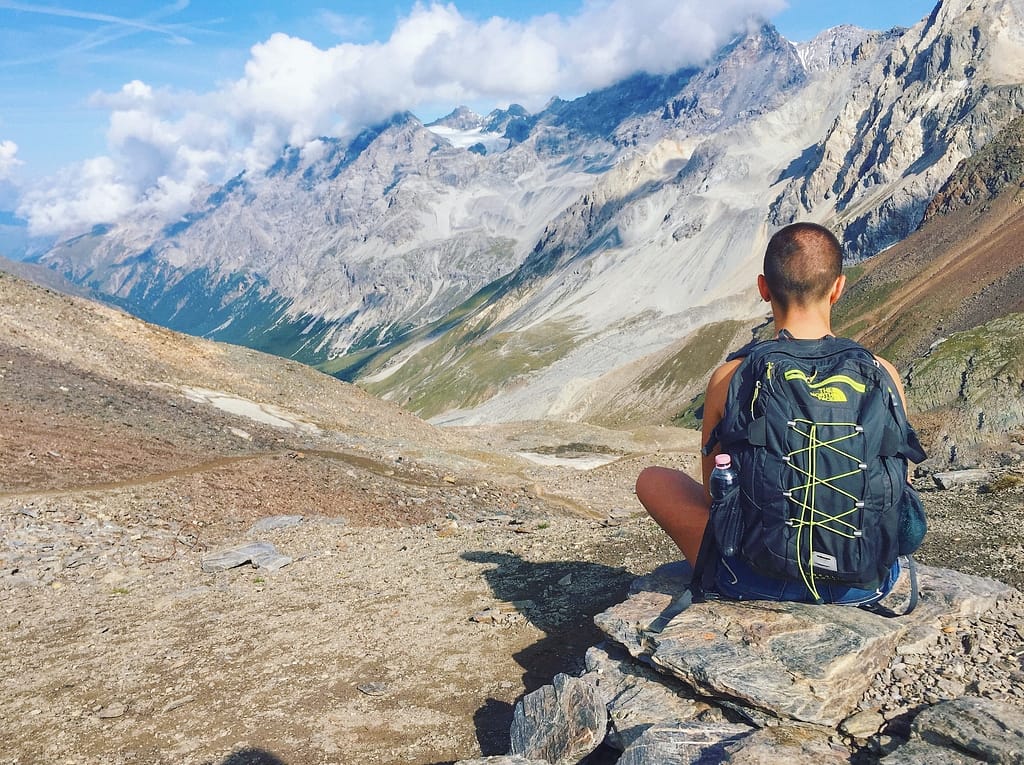 Man setting on rocky view with NorthFace Backpack