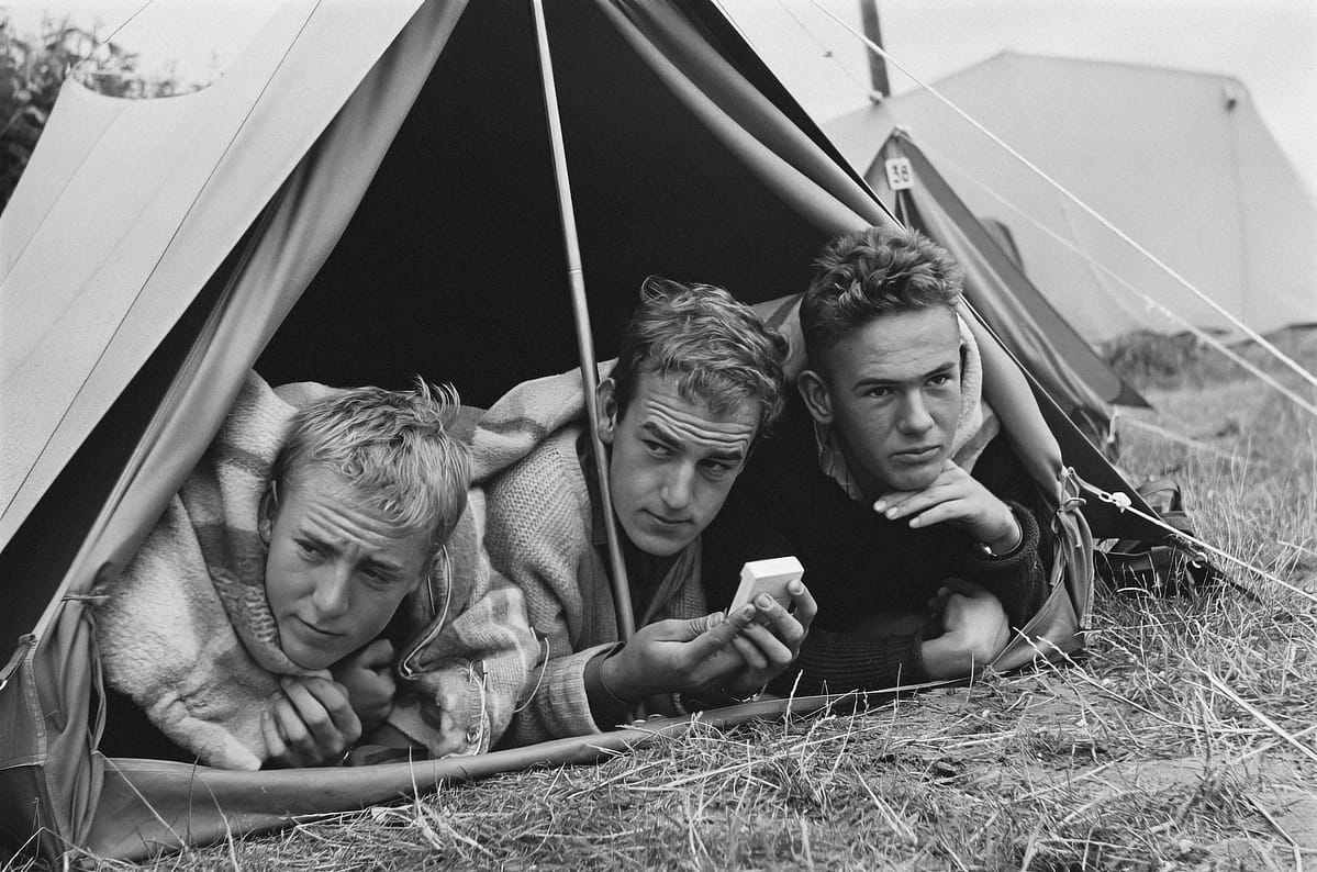 Three men inside a small tent