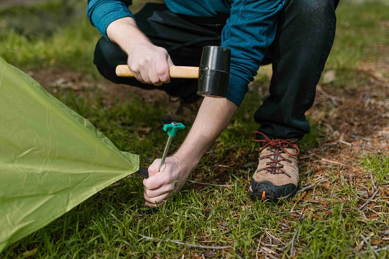 Man Stak a Tent with Mallet