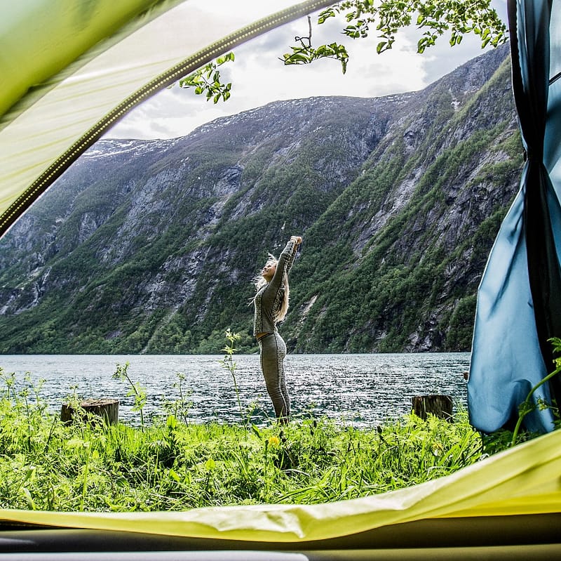 Woman standing in front of a tent while dispersed camping